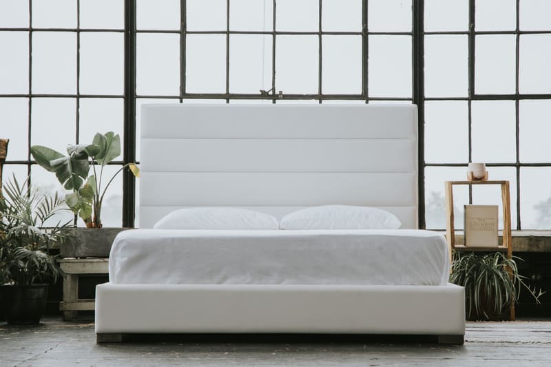 The Zazen Bed in white vegan leather with a horizontal channel headboard, straight on