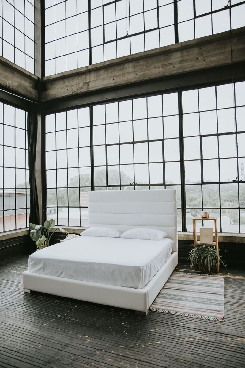 The Zazen Bed in white vegan leather, straight on, with the full headboard in view