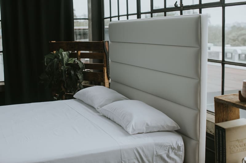 Horizontal channel headboard in white vegan leather, with pillows