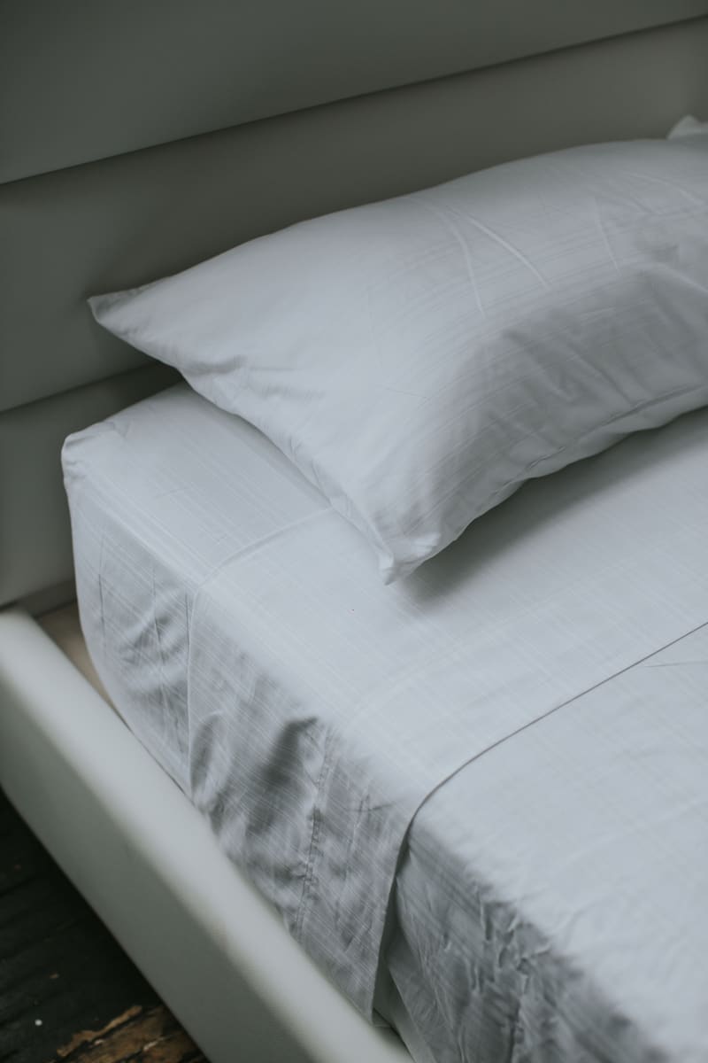 Pillow and sheets on the low platform, headboard behind