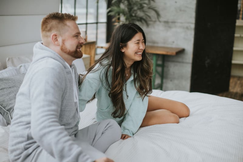 A couple laughing on the bed
